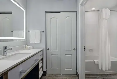 a white bathroom with a sink and a shower at Homewood Suites by Hilton London Ontario in London