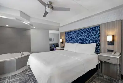 a hotel room with a bed and a bath tub at Homewood Suites by Hilton London Ontario in London