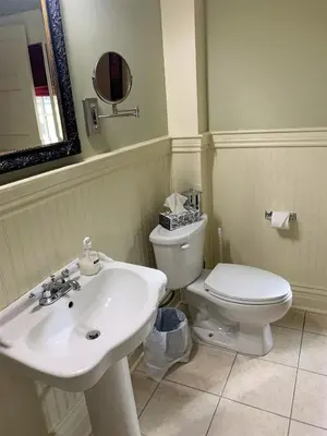 a bathroom with a sink and a toilet and a mirror at The Red Coat in Niagara on the Lake