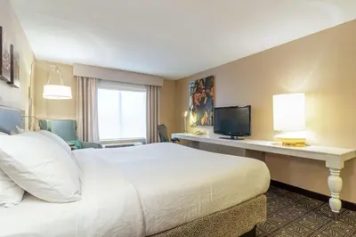 a hotel room with a bed and a desk with a television at Hilton Garden Inn Niagara-on-the-Lake in Niagara on the Lake