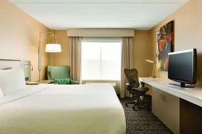 a hotel room with a bed and a flat screen tv at Hilton Garden Inn Niagara-on-the-Lake in Niagara on the Lake