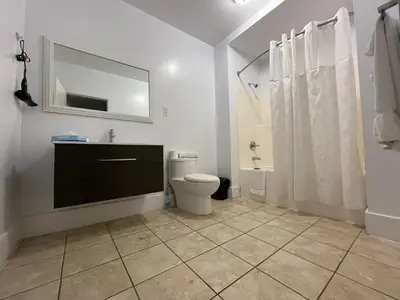 a bathroom with a toilet and a sink and a mirror at London Residency Inn in London