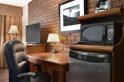 a hotel room with a desk and a tv at Travelodge by Wyndham Simcoe in Simcoe
