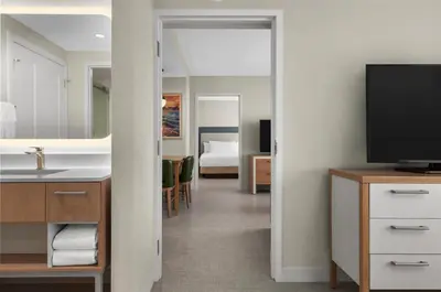 a bathroom with a sink and a television in a room at Homewood Suites by Hilton Burlington in Burlington