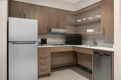 a kitchen with wooden cabinets and a white refrigerator at Homewood Suites by Hilton Burlington in Burlington