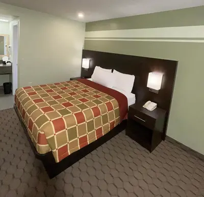 a hotel room with a bed and two night stands at Budget Inn in Port Hope