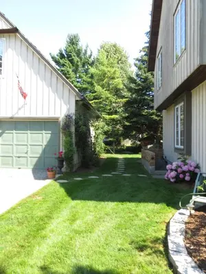 a yard next to a house with a garage at Cedar Gables Bed & Breakfast in Niagara on the Lake