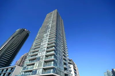 a tall glass building with two tall buildings at Pathway Suites in Mississauga