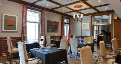 a restaurant with tables and chairs in a room at Idlewyld Inn & Spa in London
