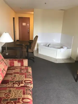 a hotel room with a bath tub and a bed at Super 8 by Wyndham Barrie South in Barrie