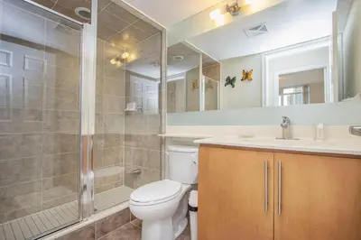 a bathroom with a toilet and a shower and a sink at Platinum Suites Furnished Executive Suites in Mississauga