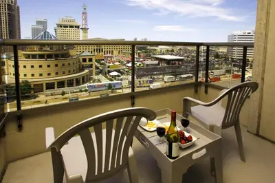 a balcony with two chairs and a table with wine bottles at Platinum Suites Furnished Executive Suites in Mississauga