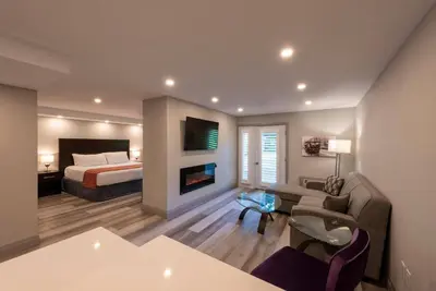 a bedroom with a bed and a living room at Georgian Bay Hotel Trademark Collection by Wyndham in Collingwood