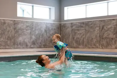 a woman and a child playing in a swimming pool at Georgian Bay Hotel Trademark Collection by Wyndham in Collingwood