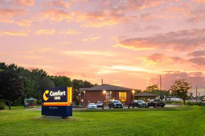a sign in front of a car dealership with a building at Comfort Inn in Midland
