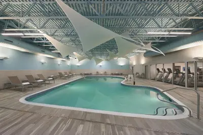 a large swimming pool in a building with chairs at Courtyard by Marriott Oshawa in Oshawa