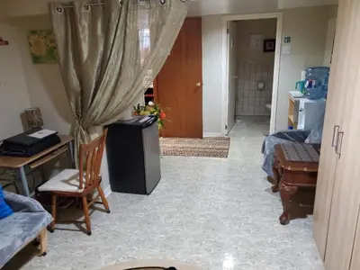a hallway with a room with two beds and a table and chairs at Private Apartment Close to Airport Toronto Pearson in Toronto