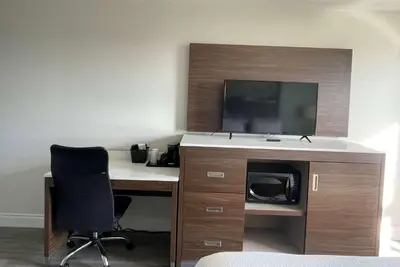 an office with a desk with a tv and a chair at Super 8 by Wyndham Peterborough in Peterborough