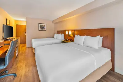 a hotel room with two beds and a television at Comfort Inn in Hamilton
