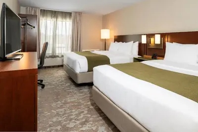 a hotel room with two beds and a flat screen tv at Comfort Inn in Hamilton