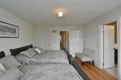 a bedroom with a bed and a chair at New Blue Mountain Village Snowbridge Executive Townhome Sleeps 10 with Outdoor Pool and Shuttle in Nottawa