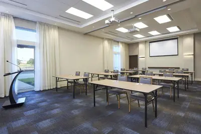 a conference room with tables and chairs and a screen at Hyatt Place Toronto Mississauga and Luxe Convention Centre in Mississauga