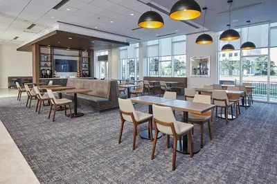 a dining room with tables and chairs and windows at Hyatt Place Toronto Mississauga and Luxe Convention Centre in Mississauga
