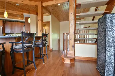 a living room with a bar and a spiral staircase at Blue Mountain-Luxurious BlueSki George Chalet, Hot Tub, Pool, Gas Fireplace in Blue Mountains