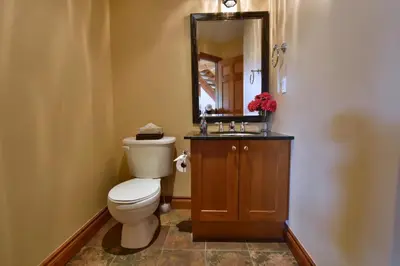 a bathroom with a toilet and a sink and a mirror at Blue Mountain-Luxurious BlueSki George Chalet, Hot Tub, Pool, Gas Fireplace in Blue Mountains