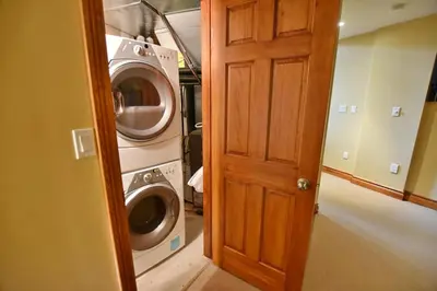 a laundry room with a washer and dryer next to a door at Blue Mountain-Luxurious BlueSki George Chalet, Hot Tub, Pool, Gas Fireplace in Blue Mountains