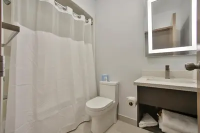a white bathroom with a toilet and a sink at King Hotel in Palmerston