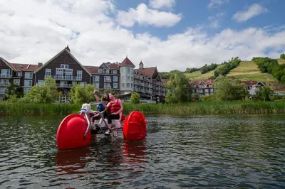 a group of people riding on a paddle board in the water at Blue Mountain Resort Home Collection in Blue Mountains
