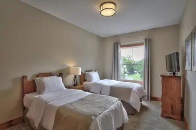 a hotel room with two beds and a television at Blue Mountain Resort Home Collection in Blue Mountains