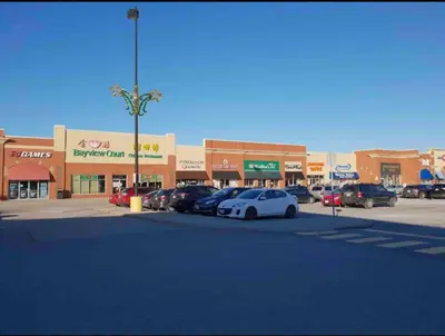 a parking lot with cars parked in front of a store at Amazing Spacious house in Center of Richmond hill in Richmond Hill