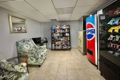 a room with a soda machine and chairs in a store at Travelodge by Wyndham Welland in Welland