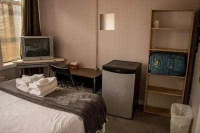 a hotel room with a bed and a desk and a tv at Saint Lawrence Residences and Suites in Toronto