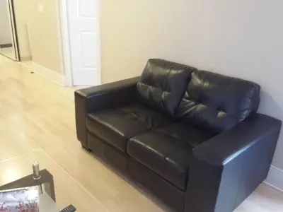 a black leather couch sitting in a living room at SPECTACULAR VIEW, 2 BEDROOMS FURNISHED CONDO and BEST LOCATION in Mississauga