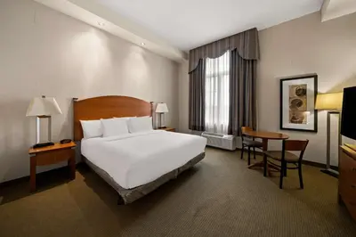 a hotel room with a bed and a table at Best Western Plus Orangeville Inn & Suites in Orangeville