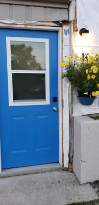 a blue garage door with a window and a potted plant at Campbellford Studio Apt 4 in Campbellford