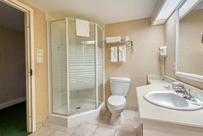 a bathroom with a toilet and a shower and a sink at The Casablanca Hotel in Grimsby