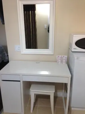 a white desk with a mirror and a microwave at Davidson Motel in Paris