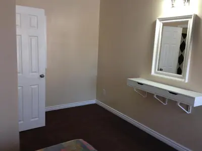 a room with a mirror and a shelf and a door at Davidson Motel in Paris