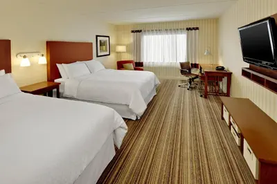 a hotel room with two beds and a flat screen tv at Four Points by Sheraton Cambridge Kitchener, Ontario in Cambridge