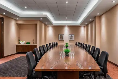 a conference room with a large wooden table and chairs at Four Points by Sheraton London in London