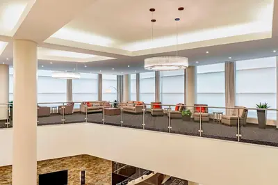 a large lobby with chairs and tables and windows at Four Points by Sheraton London in London