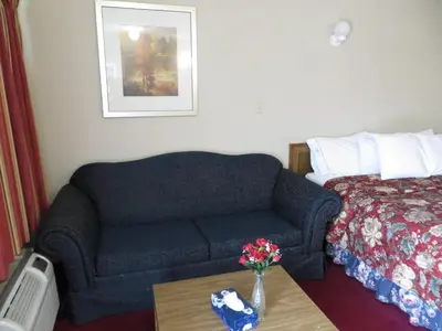 a hotel room with a couch and a bed at Good Night Inn in Port Colborne