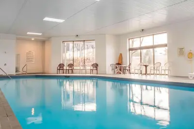 a swimming pool with chairs in a room at Quality Inn in Bracebridge