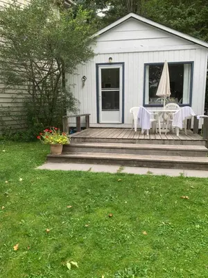 a patio with a table and chairs on a house at Beachside on Lake Muskoka in Port Carling