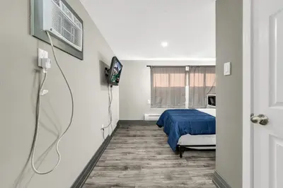 a hospital room with a bed and a tv at Park Motel in Toronto