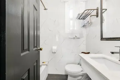 a white bathroom with a toilet and a sink at Park Motel in Toronto